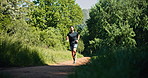 Athlete, man and running for fitness in woods with exercise, cardio training and morning routine. Person, trail runner and jog in forest for endurance workout, fresh air and improve stamina in nature