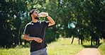 Fitness, man or drink water in nature with break for sports hydration, check smart watch or wellness. Bokeh, person outdoor and beverage with tech for exercise recovery, electrolytes or step counter.