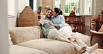 Kiss, happy couple and selfie on sofa for love, social media update and funny face in home. Smile, man and woman with photo in living room for silly profile picture, laugh and relax with partner
