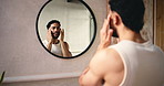 Mirror, skincare and man in bathroom with moisturizer in home for health, wellness or facial routine. Beauty, face cream and person with reflection for dermatology treatment for grooming in house.