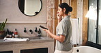 Cellphone, dental hygiene and woman brushing teeth in bathroom at hotel for morning routine on holiday. Oral care, phone and female person with social media on mobile app with mouth treatment.