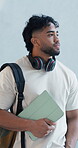 College student, man or walking in hallway with tablet for education idea, scholarship or degree. Person, headphones or tech at university with thought for academic lesson, study or skill development