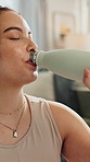 Fitness, woman and drinking water for hydration in home with exercise break, nutrition and detox. Wellness, happy girl and natural nutrients in apartment for thirst, workout rest and refreshing drink