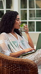 Laptop, drinking cocktail and happy woman outdoor for holiday, streaming movie and luxury resort to relax. Pc, watch film and person on vacation at hotel, weekend travel and alcohol beverage in Bali