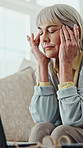 Senior woman, laptop and headache on sofa with finance, eye strain and budget review in retirement. Elderly person, migraine and temple massage with computer for relief, burnout and stress in home