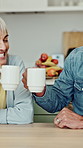 Cheers, coffee and senior couple in kitchen in home for laughing, bonding or connection together. Toast, love and elderly man with woman for drinking warm beverage in morning with support in house.