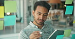 Glass, board and man writing with tablet in office for brainstorming, online research and sticky note at startup. Tech, company planning app and male employee with creative project strategy or agenda