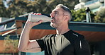 Drinking water, breathing and fitness with man outdoor for calm, hydration or training recovery. Electrolyte drink, break and health with mature person at house for sport, exercise and mineral liquid