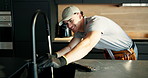 Man, plumber and wrench in kitchen with faucet installation with smile, water flow and renovation at house. Person, tap and plumbing tools for sink, home improvement or happy for property development