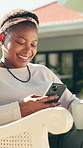 Phone, coffee and black woman relax at backyard with funny video, social media and reading blog. Mobile, tea and happy person by house outdoor for online meme, ebook app and browsing internet