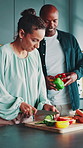 Vegetables, couple and happy with cooking help in home for healthy dinner, meal prep and nutrition. Relationship, interracial people and cut fresh ingredients in kitchen for lunch recipe and support