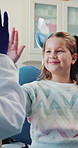 Dentist, office or happy child with high five in consultation, calm or ready for tooth extraction procedure. Trust, well done or girl at dental visit for teeth cleaning, orthodontist or good behavior