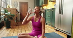 Home, drinking water and yoga with woman, meditation and wellness with break, relax and fitness. Hydration, thirsty or healthy person with routine, exercise or aqua with liquid bottle, tired or detox