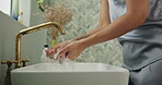 Sink, soap and washing hands with person in bathroom of home for hygiene or skincare routine. Basin, cleaning and tap with woman closeup in apartment to remove bacteria, dirt or germs for sanitation