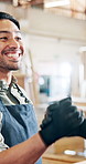 Happy man, carpenter and handshake with agreement for b2b, partnership or deal in workshop. Male person, colleagues or woodworker shaking hands with timber or lumber for project or furniture business