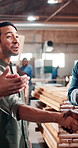 Businessman, carpenter and handshake with team for agreement, partnership or success in workshop. Male person, colleagues or woodworker shaking hands with applause for project or furniture business