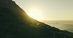 Aerial, sunrise and ocean landscape with mountain for travel destination, nature tourism and space. Drone, sunlight and natural environment with coastal view for holiday location, vacation and flare