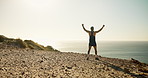 Athlete, man and hands raised in celebration at ocean for running goals, workout success and energy. Fitness, back of person and fist bump at coastal terrain for exercise achievement and adrenaline
