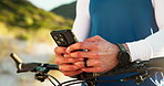 Phone, bike and fitness with hands on beach for cycling route, training app and communication. Workout guide, online cyclist map and direction search with person typing outdoor for exercise progress 