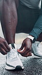 Person, hands or runner with shoe tie on road for workout preparation, exercise or outdoor training. Closeup, fitness and getting ready with sneaker or tying laces for physical activity on asphalt