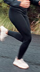 Woman, legs and running with shoes on road for cardio exercise, workout or outdoor race. Active, female person or runner with sprint, speed or motion on path, asphalt or street for fitness challenge