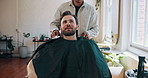 Barbershop, appointment and man with barber, haircare and discussion for hair maintenance or haircut. Salon, hairdresser and people with equipment for hairstyle, process and conversation with client