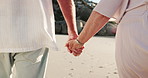 Elderly couple, holding hands and walking on beach for holiday, weekend getaway or vacation. Back view, senior man or woman with commitment, trust or support for date or summer travel on ocean coast