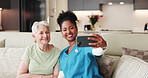 Senior woman, nurse and selfie on sofa, smile and assessment with memory in retirement home. People, caregiver and profile picture with assisted living, photography and social media on couch at house