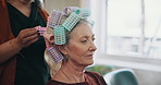 Woman, hairdresser and hands with hair rollers for beauty, curls and product in salon. Grooming, tools and mature customer with hairstylist, maintenance or hairstyle with haircare in small business
