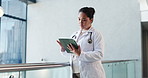 Clinic, doctor and woman with tablet for healthcare, reading email and history in hallway. Serious, person and medical worker with tech in hospital, review schedule and scroll records for telehealth
