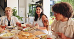Break, eating and social gathering with friends at dining table in home for bonding or reunion. Celebration, food and lunch with group of happy people in apartment for cookout, feast or meal