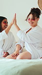 Eye mask, high five and spa day with girl friends on bed in home for bonding or celebration. Beauty, relax and skincare with excited people in bedroom of apartment for cosmetics or dermatology