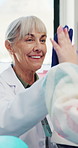 Dentist, kid and high five with dental model for hygiene education, practice success and checkup. Toothbrush, mature woman and child with celebration for cleaning demonstration or learning oral care