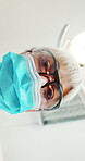 Face, dentist and woman with mask, surgery and dental lights for tooth extraction and oral procedure. Low angle, orthodontist ,and mature person with safety glasses for operation and teeth inspection