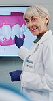Dentist, woman and talking with dental scan in office for oral education, consultation or advice. Mature person, speaking and teeth on screen for orthodontics, healthcare appointment or medical help.