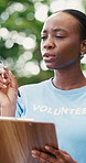 Clipboard, black woman and volunteer at food drive outdoor for checklist, inspection or inventory. Charity, nature and African female ngo worker with paperwork for planning with community outreach.