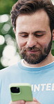 Volunteer, cellphone and happy man in park, internet and program for donation, social media and email. NGO, outdoor and person with tech, online schedule and app for sign up and community service