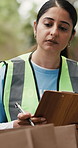Clipboard, woman and volunteer at food drive outdoor for checklist, inspection or inventory. Charity, nature and female ngo worker with paperwork for planning with community outreach project.