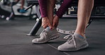 Person, hands and fitness with ankle injury for muscle tension, sprain or overworked in gym. Closeup, active or pain with sore foot or bone for strain, joint inflammation or accident in health club