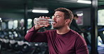 Tired man, drinking water and fitness with hydration in gym for rest, recovery or workout break. Thirsty, male person or mineral liquid with aqua, bottle or beverage for nutrition in health club