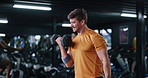 Dumbbell, fitness and intensity with man in gym for strength training or workout routine. Breathing, exercise and weightlifting with bodybuilder in health club for physical challenge or resilience