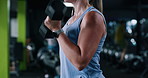 Arms, dumbbell and fitness with woman in gym for strength training or workout routine. Bicep, exercise and weightlifting with intense bodybuilder in health club for physical challenge or resilience