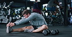 Man, fitness and stretching legs with preparation in gym for workout, exercise or indoor training. Active, male person or getting ready with warm up for flexibility or muscle recovery in health club