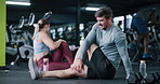Man, personal trainer and stretching for fitness at gym with exercise, training and flexibility routine. People, coach and warm up to prepare muscles, mobility workout and improve posture of wellness