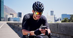 Fitness, typing or cyclist in city with phone, message or social media scroll on cycling break. Laugh, sportswear and man on road with mobile, wellness chat or internet browse in energy recovery.