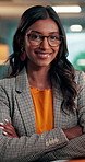 Face, smile or Indian woman in office with arms crossed, experience or pride in media job. Bokeh, glasses or journalist in newsroom with confidence, press or career growth in publishing industry.