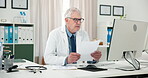 Doctor, man and computer in office with paperwork for health insurance, patient report or research. Healthcare worker, mature person or reading in clinic with desktop, medical aid document or review.