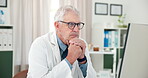 Doctor, man or thinking at computer in clinic for treatment planning, review patient info or solution. Professional, mature person or tech in practice for clinical decision or medical problem solving