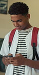 Teenager, high school or boy typing with phone, send message or check digital platform for class location. Academy schedule, reading or student in corridor with mobile app, texting or lesson info