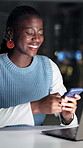 Black woman, phone and laptop at startup, night and happy with contact for story lead at media company. Person, writer and smartphone with overtime for article, smile or mobile app at creative agency
